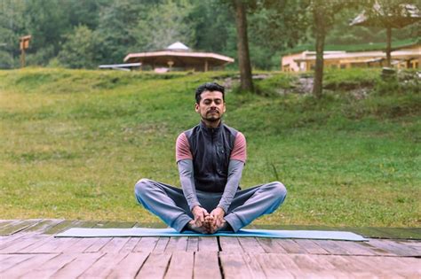 Hombre Maduro En Pose De Loto Meditando En El Bosque Foto Premium