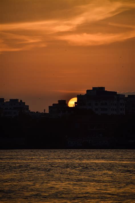 Town Silhouette behind Water at Sunset · Free Stock Photo