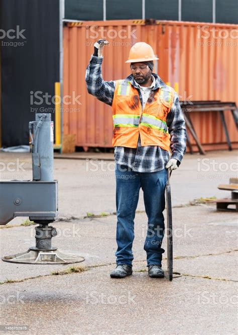 Africanamerican Construction Worker Directing Crane Stock Photo