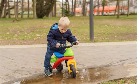 Jogo Do Menino No Parque Sua Bicicleta Running Imagem De Stock