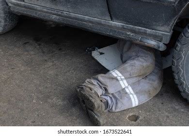 Mechanic Uniform Lying Down Working Under Stock Photo 1673522641