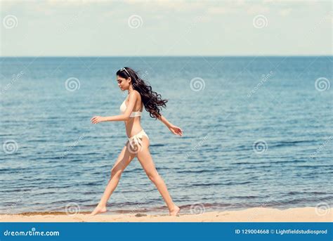 Mujer Joven Feliz En El Bikini Blanco Que Corre En La Playa Cerca De