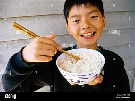 Chinese Boy Eating With Chopsticks From Rice Bowl Stock Photo Alamy