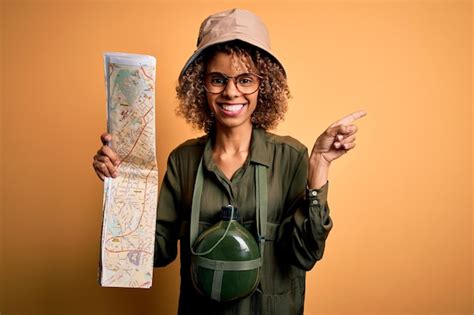 Mulher turista afro americana usando chapéu de explorador e cantil de