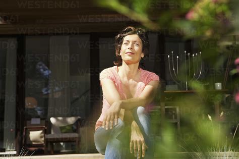 Germany Berlin Mature Woman Relaxing On Terrace Stock Photo