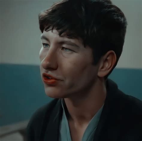 a close up of a person wearing a black jacket and orange lipstick on his lips