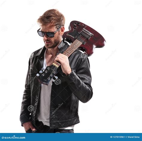 Portrait Of Relaxed Fashion Man Holding Guitar On Shoulder Stock Image