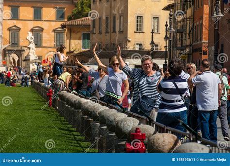 Tourists Posing And Taking Pictures In Front Of The Famous Leaning