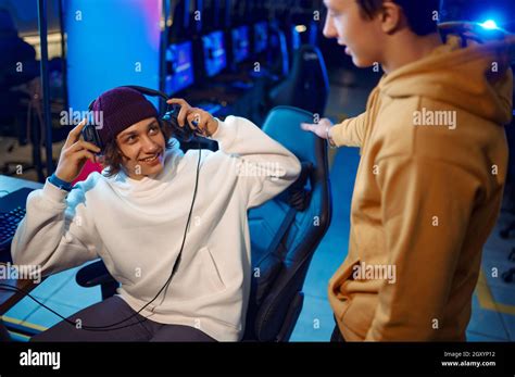 Two young gamers talking at the monitor in gaming club. Virtual ...