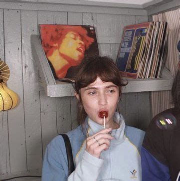 Two Women Standing Next To Each Other Eating Food