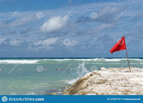 Red Caution Flag on Ocean Rock by the Beach Stock Image - Image of ...