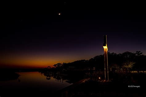 Waxing Crescent Moon With Jupiter On Top As It Sets Down Over The Creek