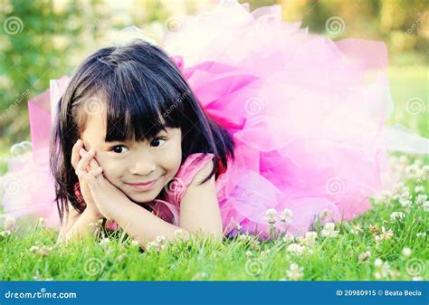 Petite Fille Heureuse S étendant Sur L herbe En Stationnement Image