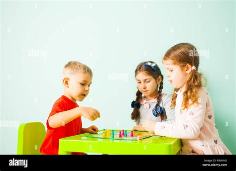 Three kids playing ludo game at home Stock Photo - Alamy