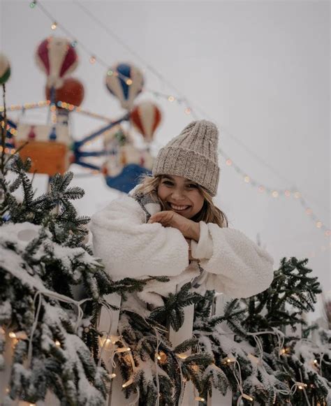 A Woman Standing Next To A Christmas Tree