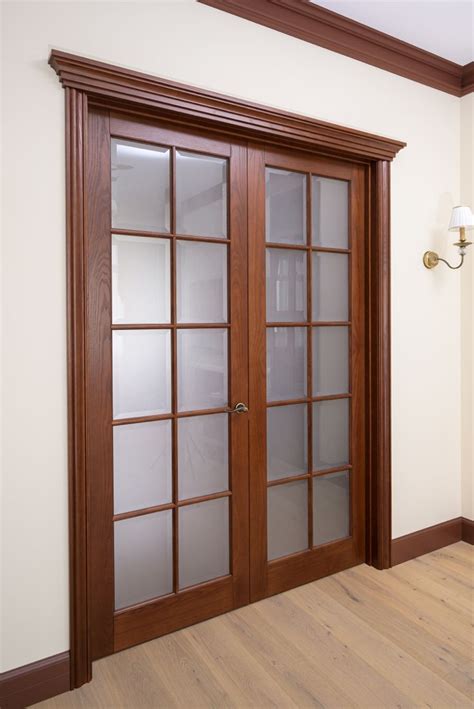 an empty room with wooden doors and hard wood flooring