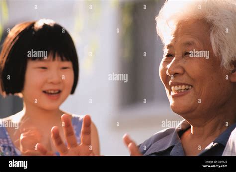 Chinese Grandmother And Her Granddaughter Playing Together Happily