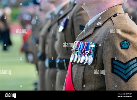 A British Army Sergeant Major Wears Medals And A Red Sash While On