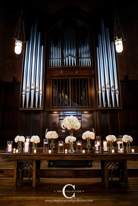 A Long Table With Candles And Flowers On It In Front Of A Pipe Organ