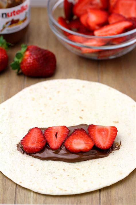 A Tortilla With Chocolate And Strawberries In The Middle On A Wooden Table