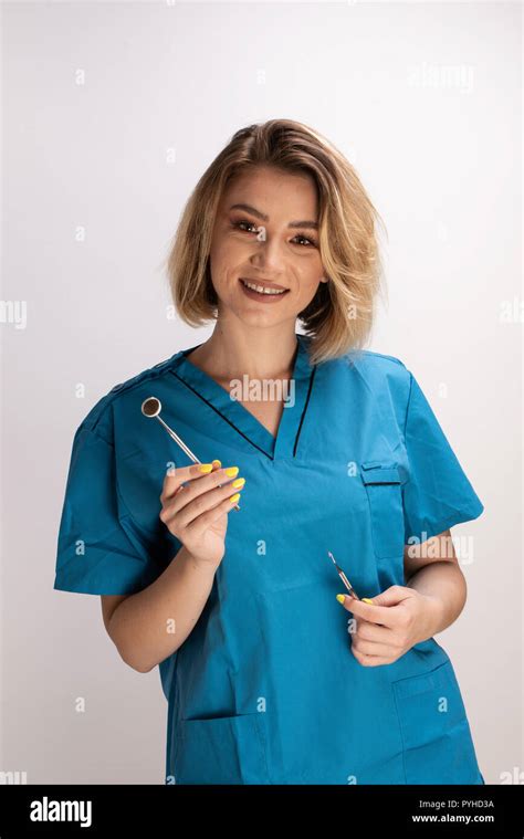 Female Dentist Holding A Mirror And Dental Tools Confident Smiling