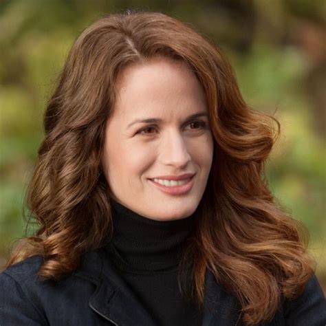 A Close Up Of A Person Wearing A Black Jacket And Smiling At The Camera