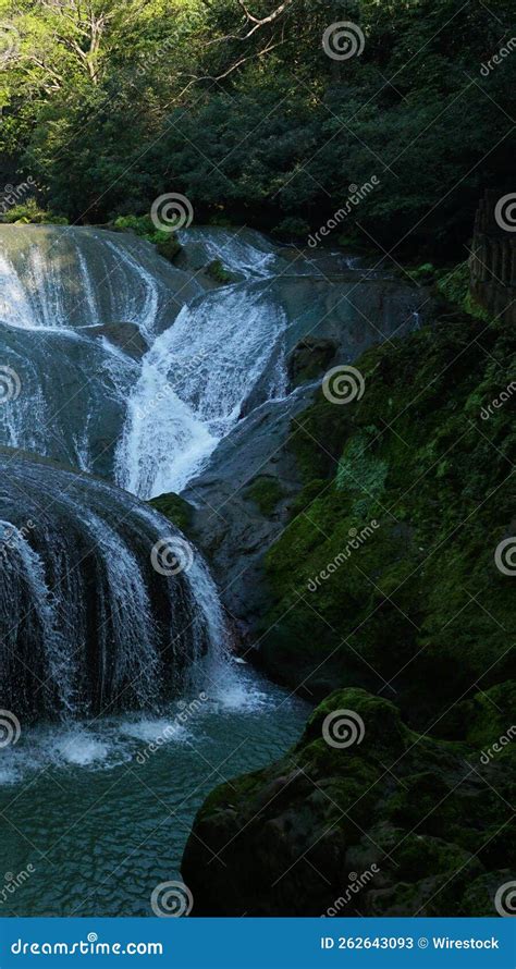 Toma Vertical De Una Cascada En El Bosque Verde Imagen De Archivo