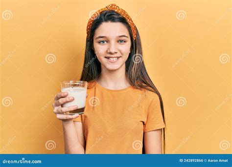 Young Brunette Girl Drinking A Glass Of Milk Looking Positive And Happy