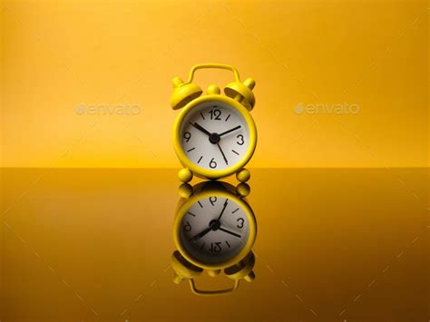 Yellow Alarm Clock On Yellow Background With Reflection On A Black