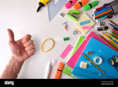 Assortment Of Colorful School Supplies On White Desk And Hand With Ok