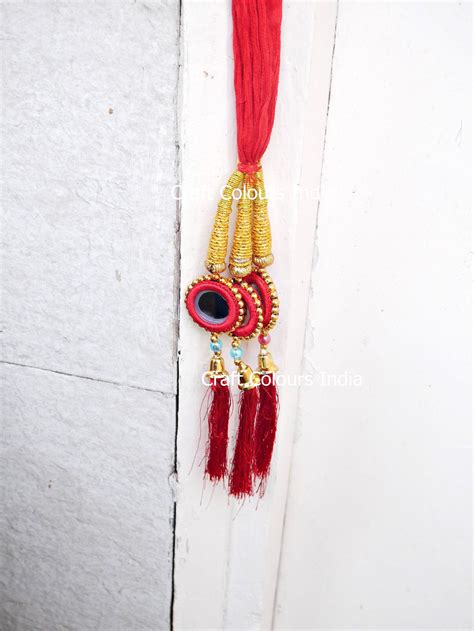 a red and gold tassel hanging from a door