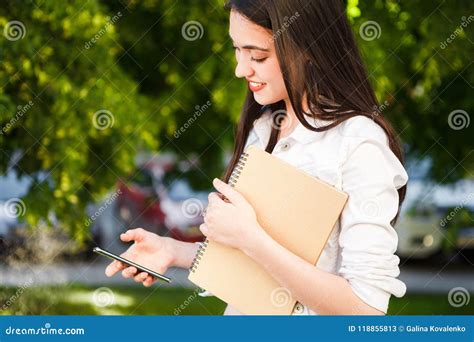 Het Meisje Spreekt Op De Telefoon In De Straat Met Een Notitieboekje In