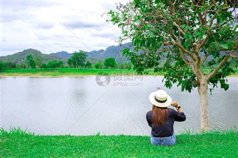 女人戴着帽子坐在大湖边高清图片下载 正版图片506673933 摄图网