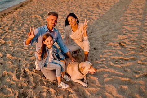 Familia Con Perro En La Playa Foto Premium