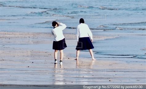 海で友達の写真を写す制服姿の女子高生の写真・画像素材 5772292 Snapmart（スナップマート）