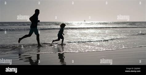 Silueta De Padre E Hijo Correr En La Playa De Verano Al Aire Libre