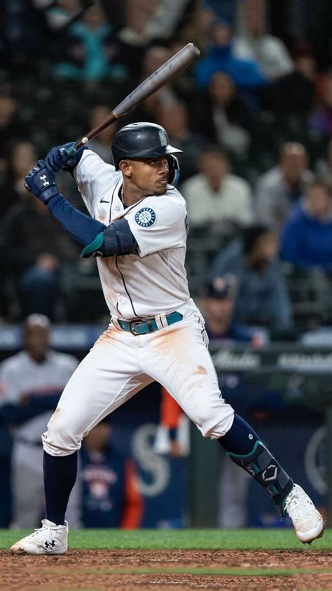 A Baseball Player Holding A Bat On Top Of A Field In Front Of A Crowd