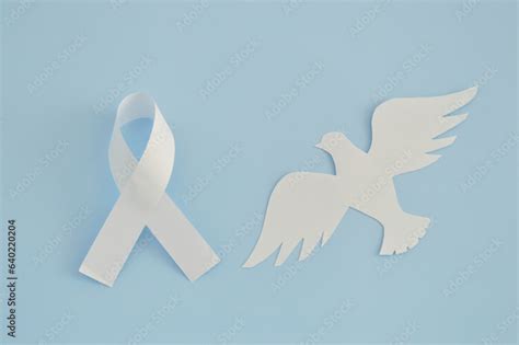 White Ribbon As A Symbol Of Peace And Paper Bird On Blue Background