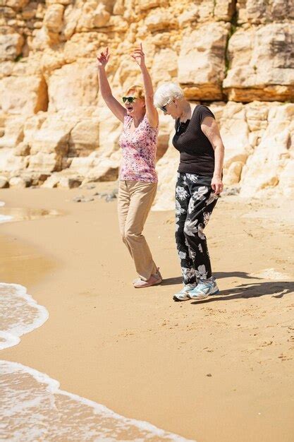 Premium Photo Two Senior Women Walking Along The Rocky Seashore And