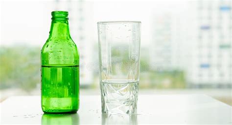 Green Bottle and Clear Glass of Water Stock Photo - Image of empty ...