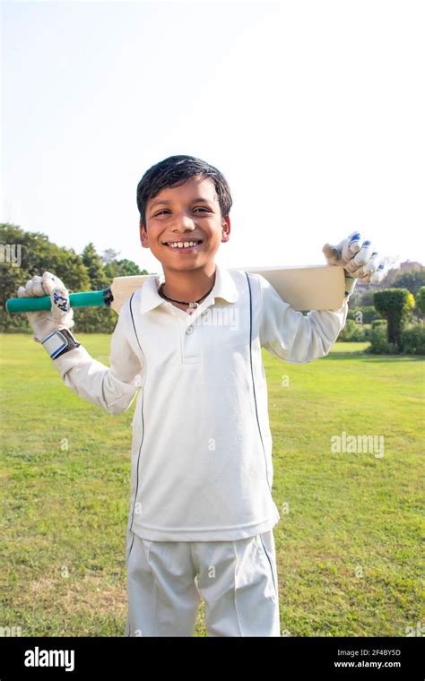 Boy in cricket uniform holding a cricket bat Stock Photo - Alamy