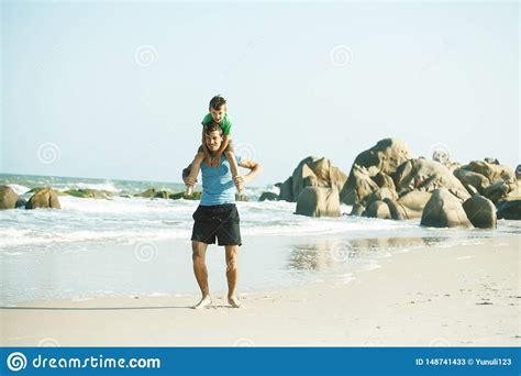 Familia Feliz En La Playa Que Juega Padre Con La Costa De Mar Del Hijo