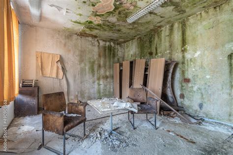 Old abandoned and run-down room in a hotel with destroyed chairs, table ...