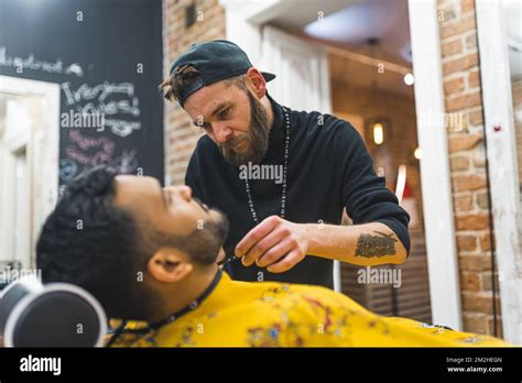 Professional Bearded Barber Trims The Beard Of His Client Blurred