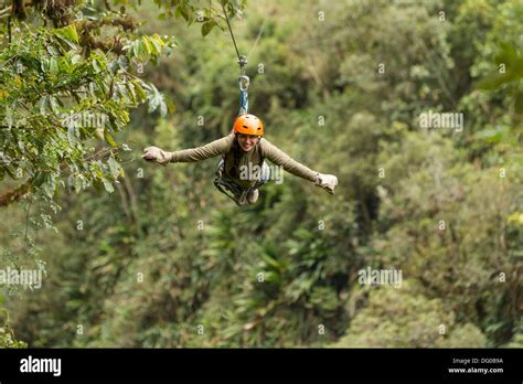 Happy Adult Woman On Zip Line Above Dense Vegetation In South America ...