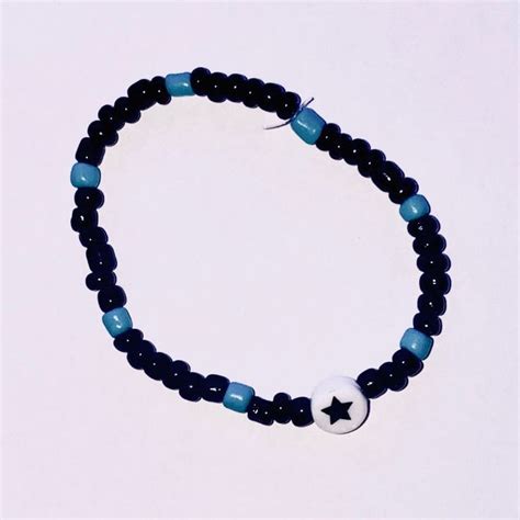 A Beaded Bracelet With A Black And White Star Charm On It S Side