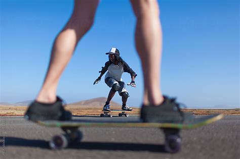 Friends Having Fun Riding A Longboard In The Desert By Hex Stocksy