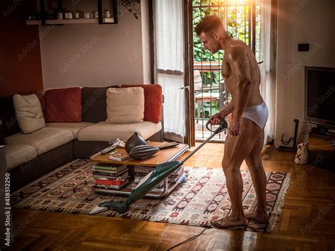 Sexy Naked Muscular Man Cleaning Floor With Vacuum Cleaner In His