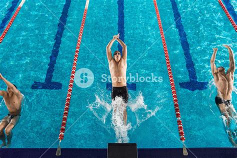 Top View Of Three Male Swimmers Beginning A Back Stroke Race Royalty