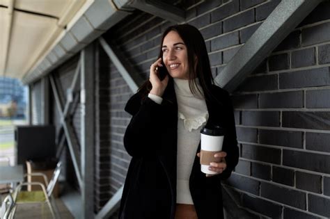 Mujer de negocios de mediana edad hablando por un teléfono móvil con